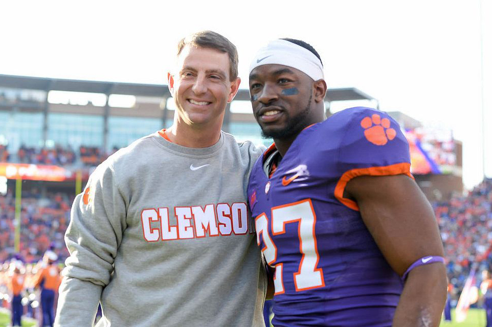 football player posing with coach clemson university tigers dabo swinney