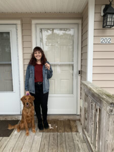 team member in front of her new home