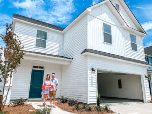 team members in front of their new home